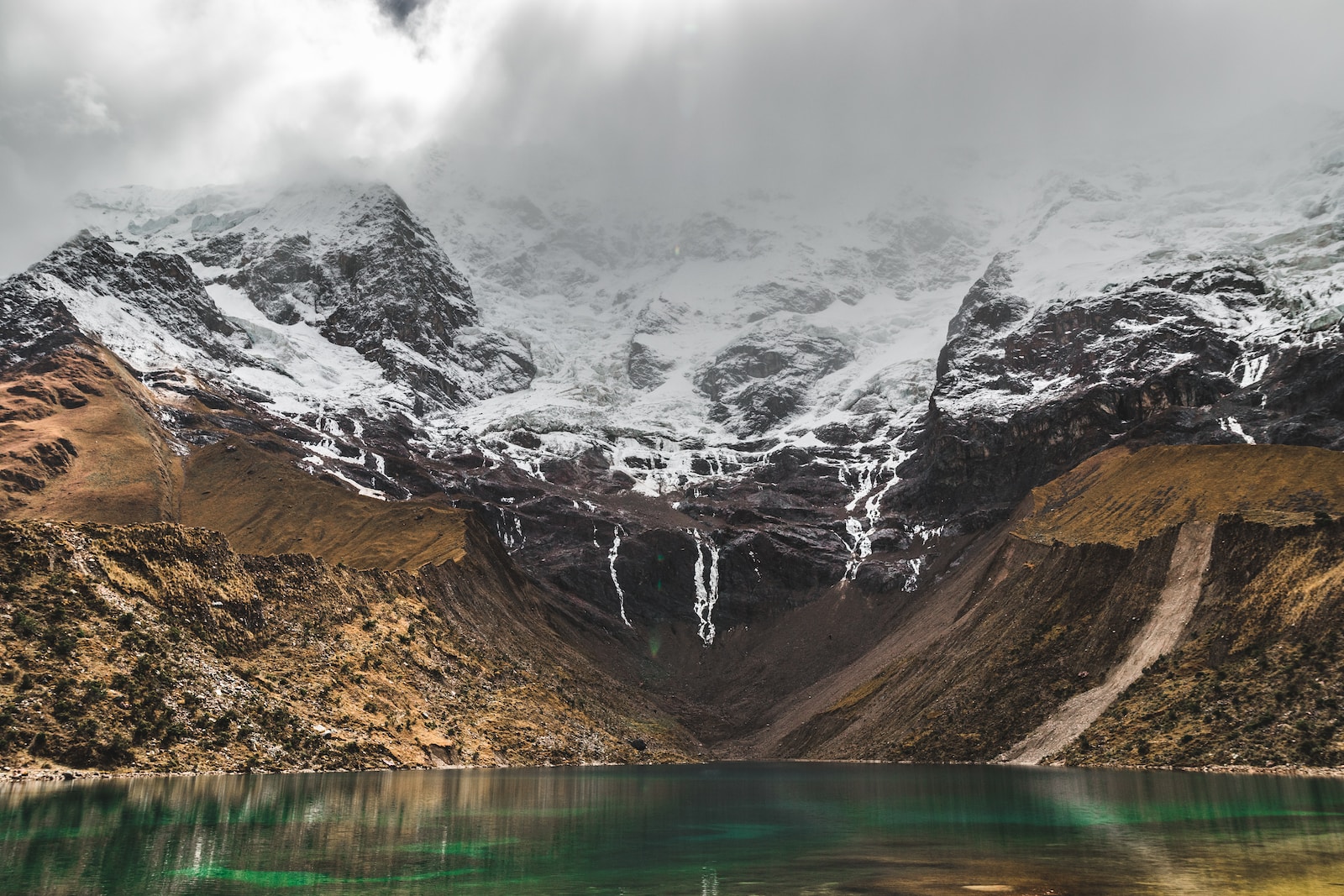 body of water near snow-covered mountain